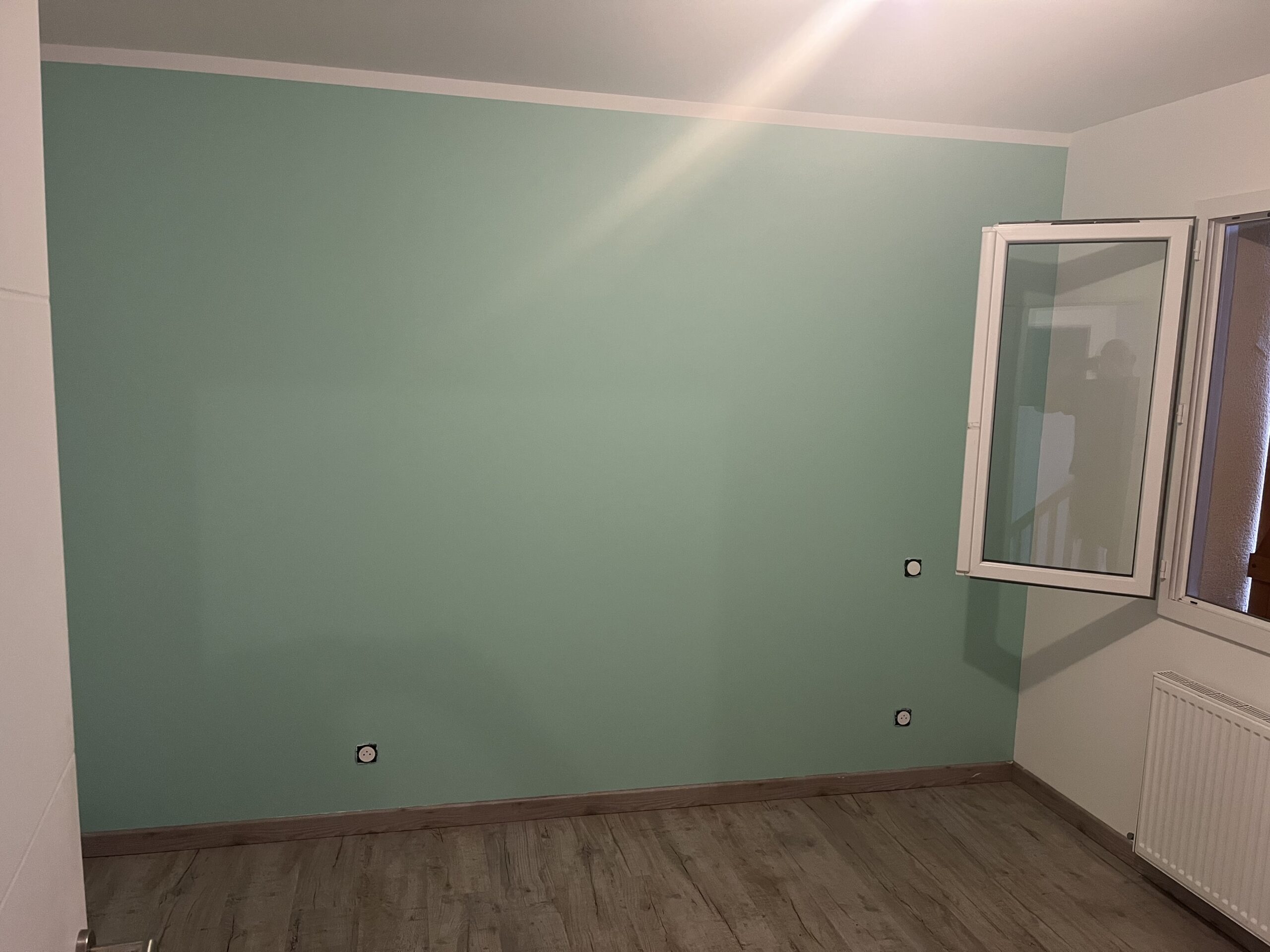 Application d'une peinture verte mat profond d'une chambre enfant 