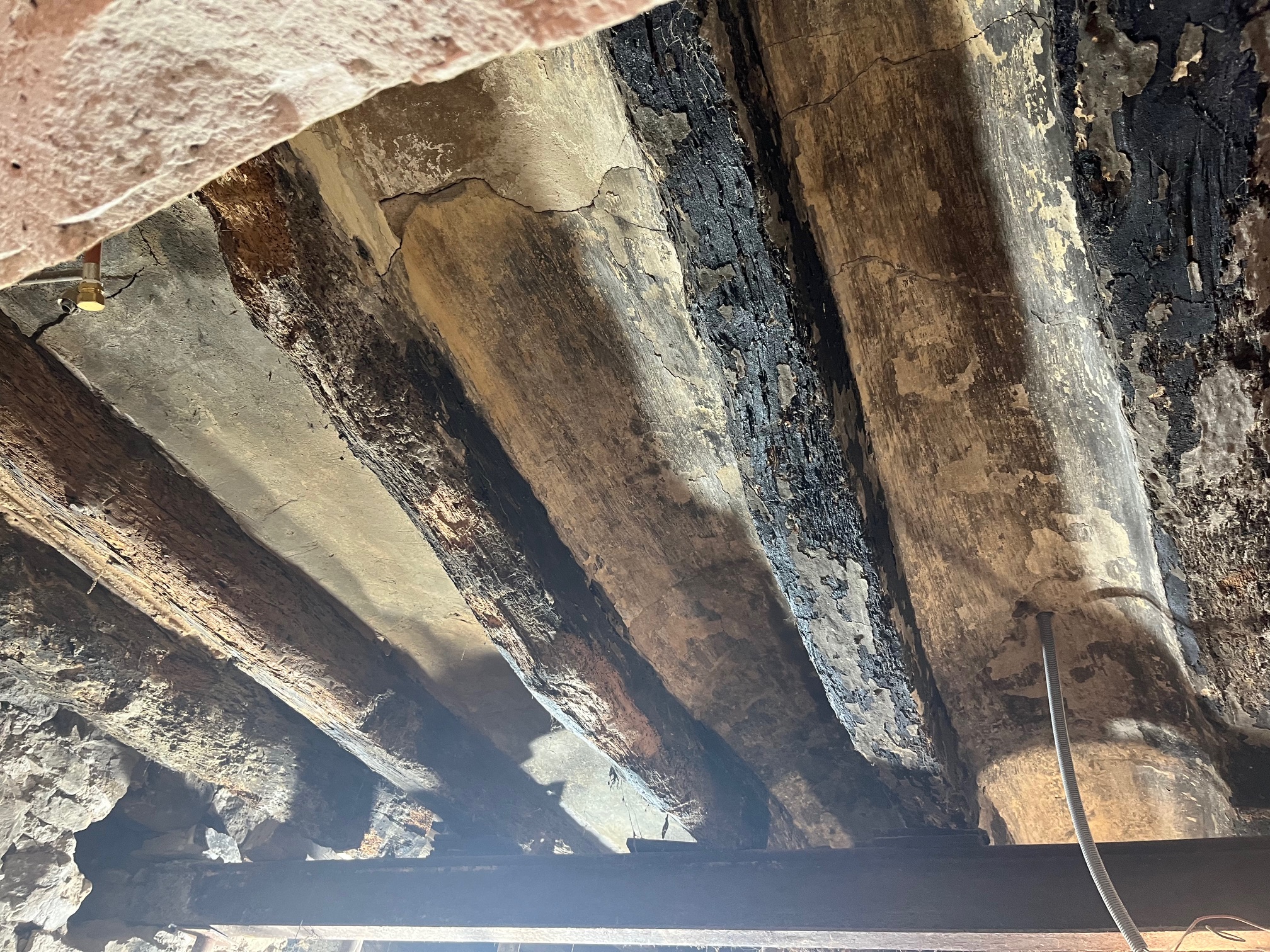 Travaux de nettoyage de poutres bois après incendie 