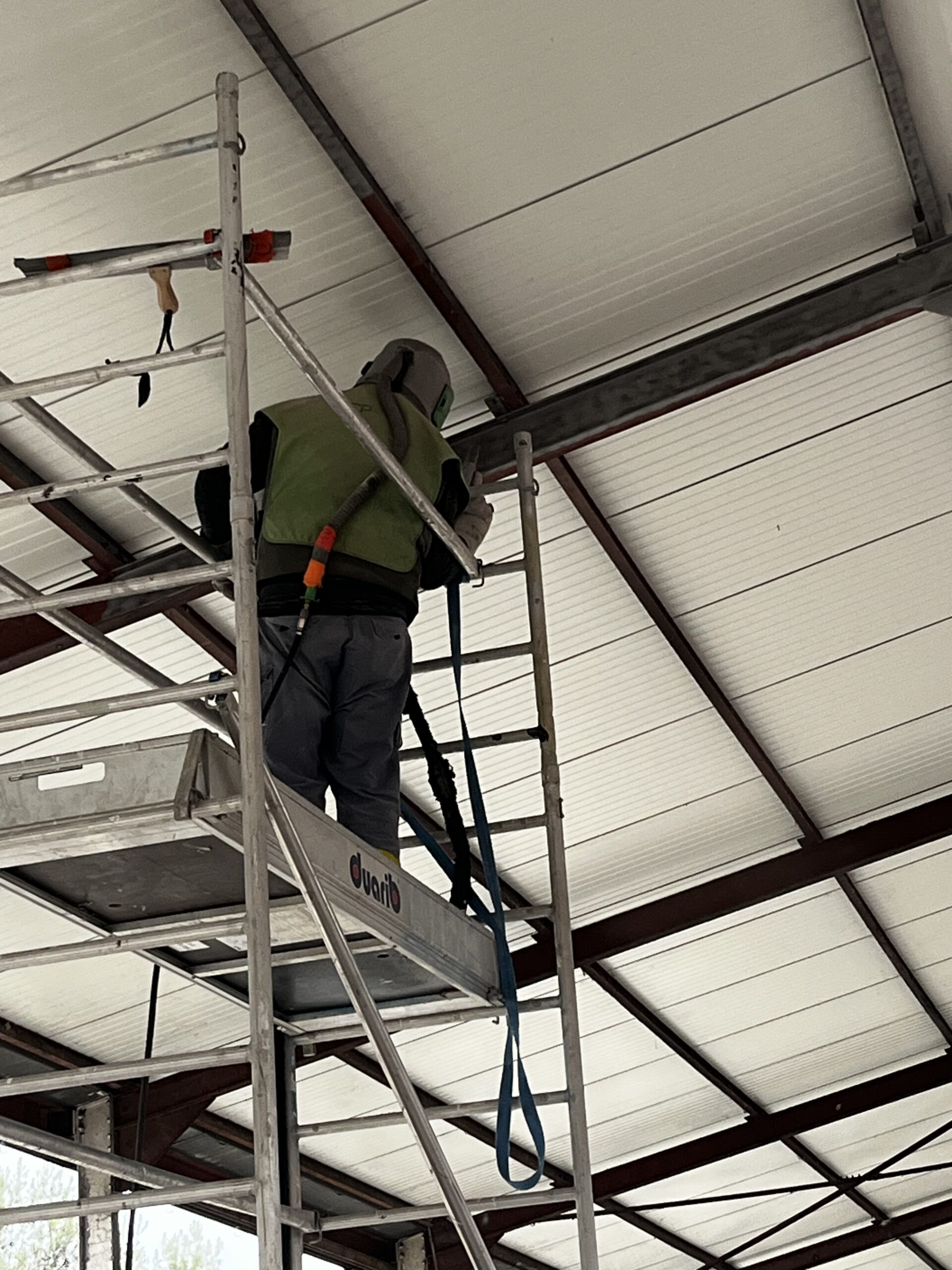 Travaux en cours d'aérogommage de charpente métallique