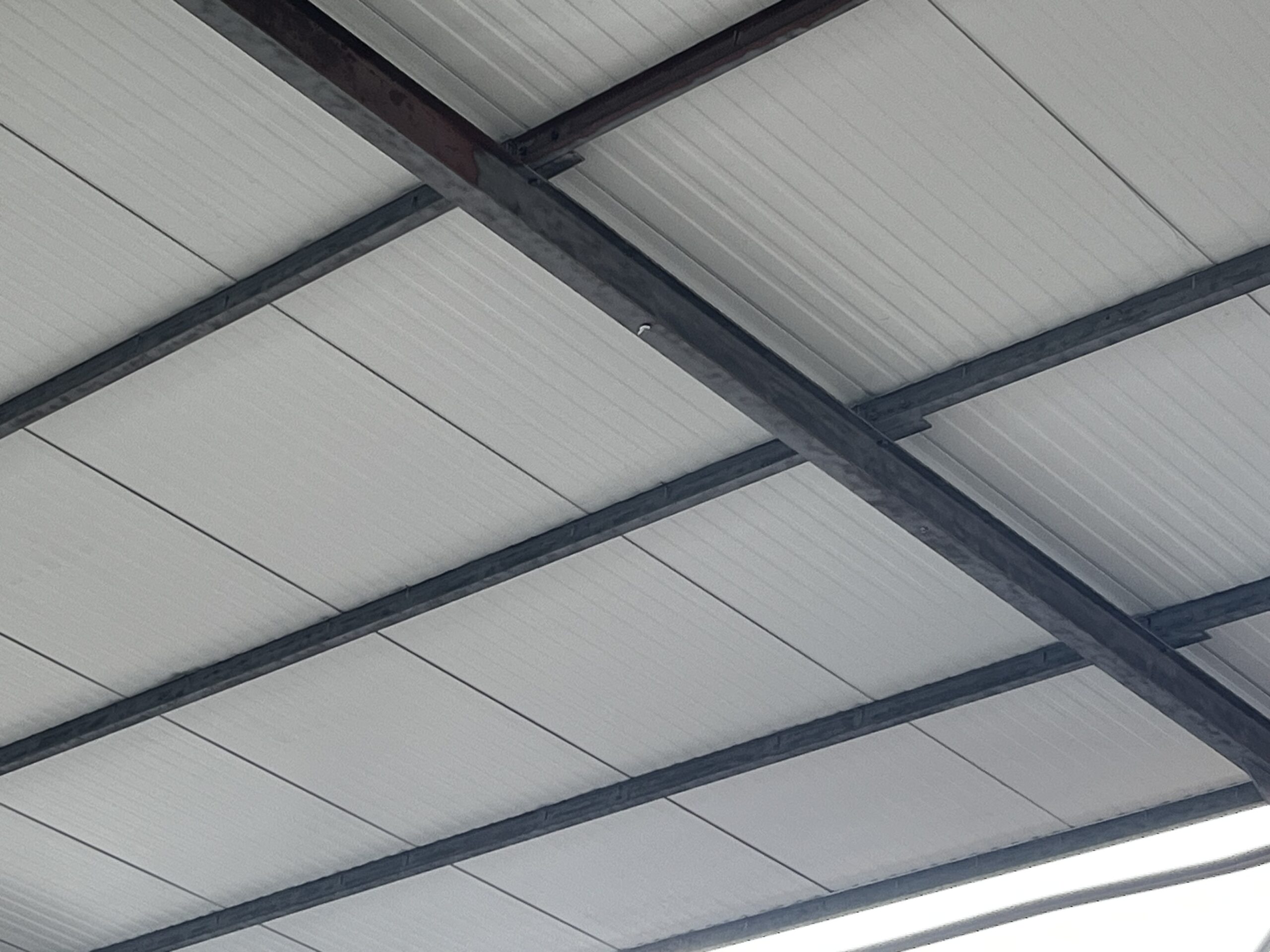 Photo démontrant avec précision l'aérogommage de charpente métallique sans toucher la sous face du plafond