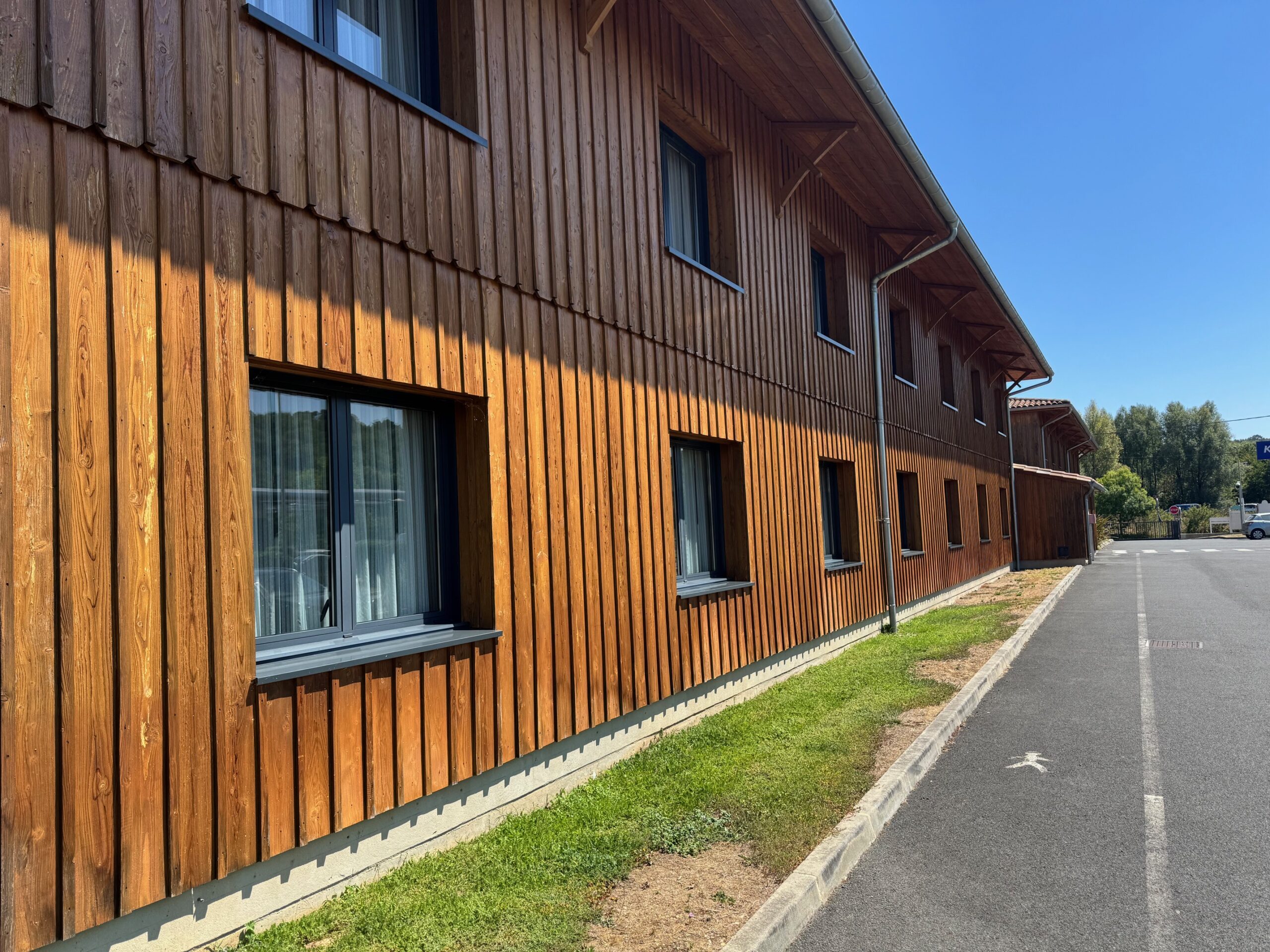 Application d'un saturateur ignifuge sur un bardage en bois vertical d'un hôtel